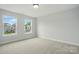A bright bedroom with neutral carpet and trim, featuring two windows with neighborhood views at 2020 Embassy Ct # 48, Charlotte, NC 28213