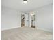 A bright bedroom with neutral carpet and trim, featuring an ensuite bathroom and easy access to other rooms at 2020 Embassy Ct # 48, Charlotte, NC 28213