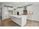 Open concept kitchen featuring a large island, pendant lights, and stainless steel hood at 2020 Embassy Ct # 48, Charlotte, NC 28213