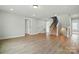 Bright living room with wood-look flooring and stairway access to upper level at 2020 Embassy Ct # 48, Charlotte, NC 28213
