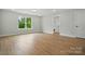 Bright living room with wood-look flooring and a large window overlooking green space at 2020 Embassy Ct # 48, Charlotte, NC 28213