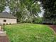 Wide backyard view featuring a lush lawn, mulched areas, and a partial view of the home at 2417 Calais Pl, Charlotte, NC 28211