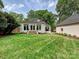 A manicured backyard with a lush lawn, a white brick home, and outdoor living spaces at 2417 Calais Pl, Charlotte, NC 28211