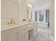 Bright bathroom featuring dual sinks, natural light, blue tile accents, and a standalone bathtub at 2417 Calais Pl, Charlotte, NC 28211