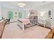 Bright bedroom featuring hardwood floors, three windows, and a bed with colorful floral bedding at 2417 Calais Pl, Charlotte, NC 28211