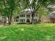 Traditional two-story home with black shutters, a manicured lawn, and mature trees at 2417 Calais Pl, Charlotte, NC 28211