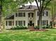 Beautiful traditional home featuring white painted brick, black shutters, dormers, and mature landscaping at 2417 Calais Pl, Charlotte, NC 28211
