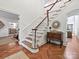 Foyer with wood staircase, herringbone wood floors, and decorative table with mirror at 2417 Calais Pl, Charlotte, NC 28211