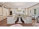 Spacious kitchen with a u-shaped center island featuring a built-in table, pristine white cabinets, and wooden countertops at 2417 Calais Pl, Charlotte, NC 28211