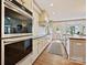 Well-lit kitchen boasting stainless steel appliances, a long countertop, and crisp, white cabinets and backsplash at 2417 Calais Pl, Charlotte, NC 28211