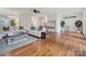Open living room with hardwood floors, white sofas, and access to backyard at 2417 Calais Pl, Charlotte, NC 28211