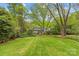 Expansive backyard with lush greenery, mature trees, and well-kept lawn, creating a peaceful outdoor retreat at 2418 Ainsdale Rd, Charlotte, NC 28226