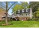 Spacious backyard with lush green grass, mature trees, and a charming home with a deck and walkout basement at 2418 Ainsdale Rd, Charlotte, NC 28226