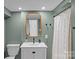 Cozy bathroom featuring a gold framed mirror, a single sink vanity, and shower with curtain at 2418 Ainsdale Rd, Charlotte, NC 28226