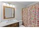 Bathroom with wood vanity, quartz countertops, decorative shower curtain, and ample lighting at 2418 Ainsdale Rd, Charlotte, NC 28226