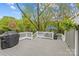 Spacious gray deck with white railings featuring a grill, umbrella, and a view of the surrounding trees and backyard at 2418 Ainsdale Rd, Charlotte, NC 28226