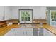 Bright kitchen features a stainless steel sink, modern appliances, white cabinets, and a garden window view at 2418 Ainsdale Rd, Charlotte, NC 28226