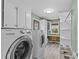 Well-lit laundry room with storage cabinets, a built-in desk, and modern appliances at 2418 Ainsdale Rd, Charlotte, NC 28226