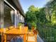 A cozy balcony with wooden table and chairs overlooks a lush green landscape, perfect for outdoor dining at 2900 #G Heathstead Pl, Charlotte, NC 28210