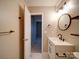 Updated bathroom with modern vanity, round mirror, and black hardware at 2900 #G Heathstead Pl, Charlotte, NC 28210