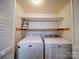 Convenient laundry room with modern washer and dryer, as well as shelving for storage at 2900 #G Heathstead Pl, Charlotte, NC 28210