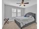 A neutral bedroom with a gray upholstered bed, carpet and a ceiling fan at 3075 Jamestown Dr, Gastonia, NC 28054