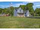 Inviting two-story blue home with brick accents, featuring a spacious lawn and mature trees at 3075 Jamestown Dr, Gastonia, NC 28054