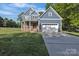 Charming two-story blue home featuring a two-car garage, front porch, and well-manicured lawn at 3075 Jamestown Dr, Gastonia, NC 28054