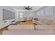 Bright living room featuring a sectional sofa, plantation shutters and a large-screen TV at 3075 Jamestown Dr, Gastonia, NC 28054