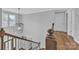 A staircase with a decorative light fixture, wood banister, and hardwood flooring at 3075 Jamestown Dr, Gastonia, NC 28054