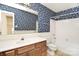 Bathroom featuring blue floral wallpaper, a tub-shower combo, and a vanity, combining classic design with practical features at 317 Port Royal Dr, Matthews, NC 28105