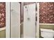 Bathroom featuring a shower with glass doors and floral wallpaper, blending functionality with a decorative touch at 317 Port Royal Dr, Matthews, NC 28105