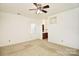 Bright bedroom featuring a ceiling fan, neutral carpet, and an attached bathroom, providing comfort and convenience at 317 Port Royal Dr, Matthews, NC 28105