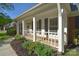 Inviting front porch with white columns, black shutters, and attractive landscaping at 317 Port Royal Dr, Matthews, NC 28105