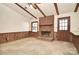 Comfortable living room with brick fireplace, wood paneling, and beamed ceiling at 317 Port Royal Dr, Matthews, NC 28105