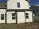 Home's back exterior view featuring vinyl siding, windows, and well-maintained lawn at 3173 Pinehills Way, Mount Holly, NC 28120