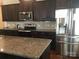Kitchen with stainless steel appliances, granite countertops, and dark wood cabinets at 3173 Pinehills Way, Mount Holly, NC 28120