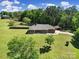 Aerial view of a brick home with a large yard, mature trees, and separate garage at 3270 Kings Row Dr, Rock Hill, SC 29732