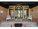 Inviting brick front porch with stylish seating and arched windows flanking the front door at 3270 Kings Row Dr, Rock Hill, SC 29732