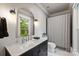 Bathroom featuring a marble countertop, stylish mirror, and modern fixtures and striped shower curtain at 3300 Sharon Rd, Charlotte, NC 28211