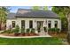 A well-maintained home with a stone staircase, a beautifully landscaped yard, and a classic white facade at 3300 Sharon Rd, Charlotte, NC 28211