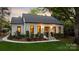 Charming white brick home with landscaped yard, stone steps, black trim windows, and a welcoming entrance at 3300 Sharon Rd, Charlotte, NC 28211
