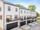 Back exterior view of modern townhomes with garages, balconies, and well-maintained landscaping at 360 N Broad St, Waxhaw, NC 28173