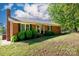 Charming single story red brick home featuring mature trees, shutters, and an inviting front entrance at 3842 Harmony Rd, Catawba, SC 29704
