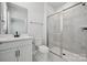 Modern bathroom features a glass-enclosed shower, marble-style tile, and a vanity with a black faucet at 404 Balboa St, Matthews, NC 28104