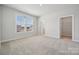 A light-filled bedroom with neutral carpet, a large window, and access to a walk-in closet and bathroom at 404 Balboa St, Matthews, NC 28104