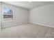 Sunny bedroom with plush carpet, one large window, and neutral walls at 404 Balboa St, Matthews, NC 28104