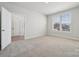 Bright bedroom with neutral walls, plush carpeting, and a window offering natural light and neighborhood views at 404 Balboa St, Matthews, NC 28104