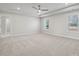 Large bedroom with neutral carpet, tray ceiling, and natural light from the windows at 404 Balboa St, Matthews, NC 28104