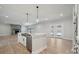Open kitchen island and living space with stone fireplace, stainless sink and stainless steel appliances at 404 Balboa St, Matthews, NC 28104